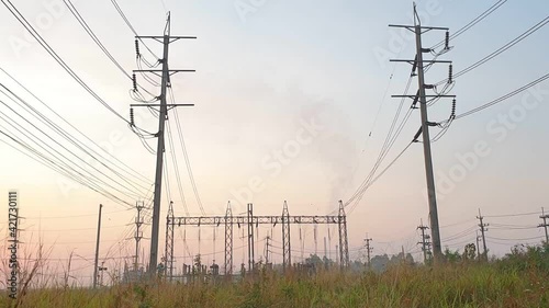 Electricity substation with green grass field in the morning light, Transmission line of electricity to rural field, Electricity tower with green nature landscape