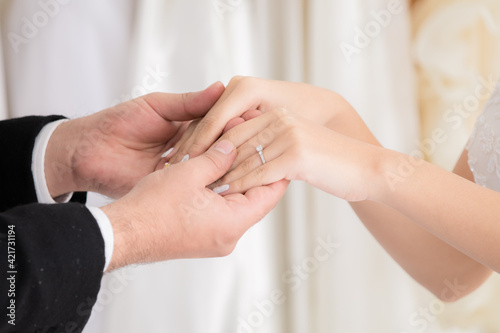 Newlywed or wedding ceremony preparation couple lifestyle concept, Mix race, beautiful Asian girl and Caucasian man eye contact together with love passion, hand hold together with wedding gold rings