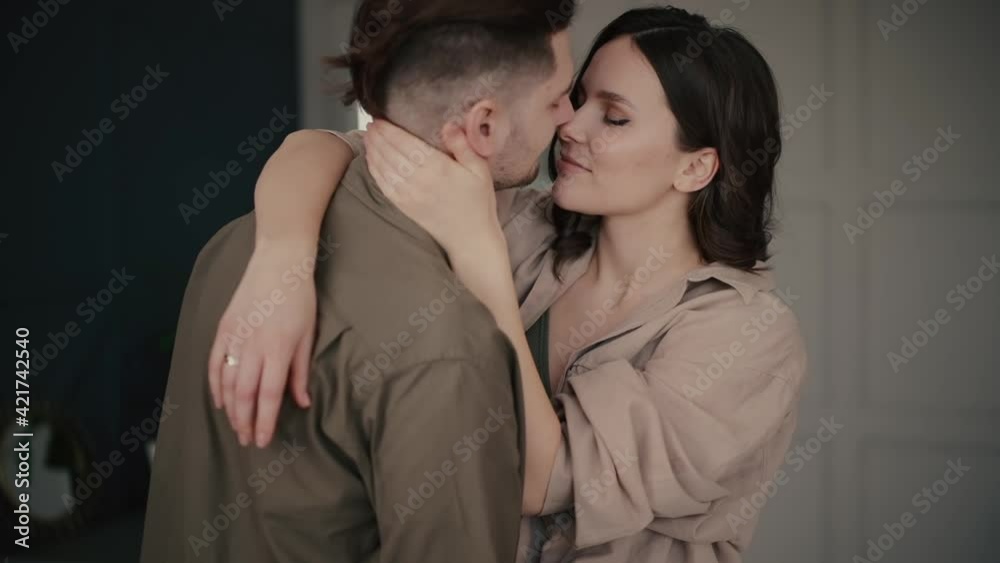 Cheerful stylish passionate family couple dances and kisses spending time together in contemporary room at home slow motion Cheerful stylish passionate family couple dances and kisses spending time together in contemporary room at home slow motion