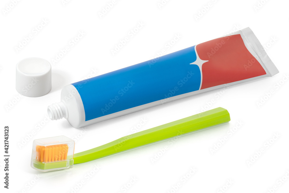 A tube of red and blue toothpaste and a toothbrush on a white