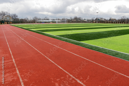Sports stadium with artificial turf green grass on a professional football field. Running Artificial Rubber Stadium Sports Tracks