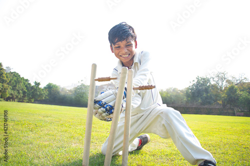 Photography a boy wicket keeper stumping during cricket game