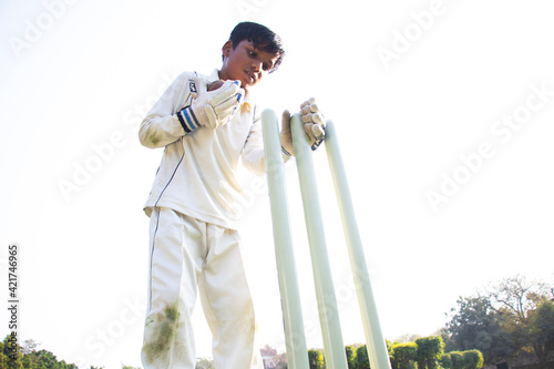 Canvas Print a boy wicket keeper during cricket game