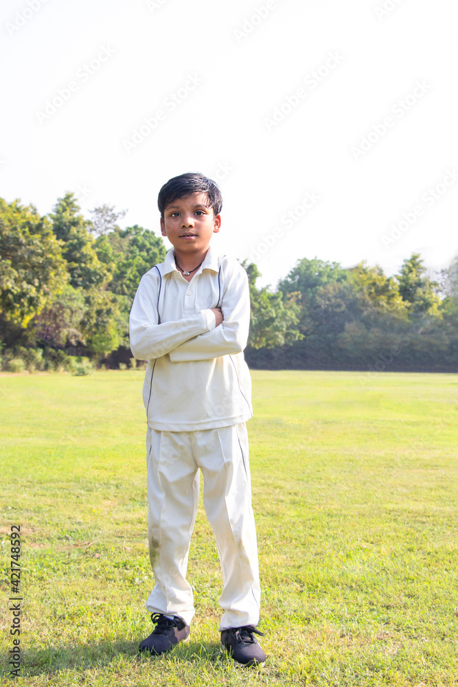 a boy wearing a cricket uniform and standing