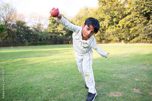 Canvas Print Young boy bowling leg spin in a cricket