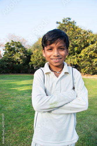 A boy in cricket uniform standing