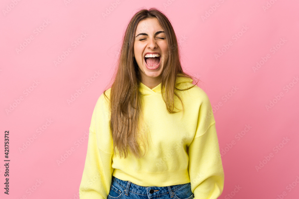 Young woman over isolated pink background shouting to the front with mouth wide open Young woman over isolated pink background shouting to the front with mouth wide open