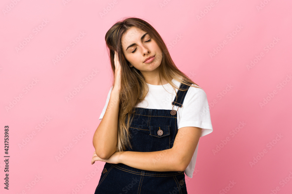 Young woman over isolated pink background with headache Young woman over isolated pink background with headache