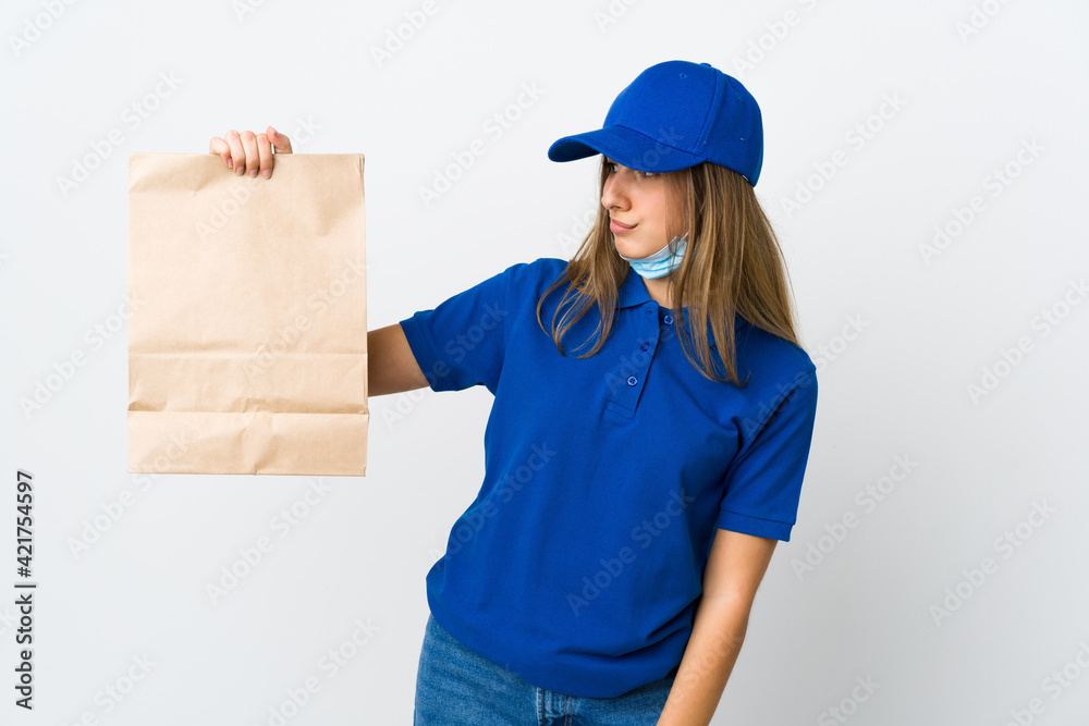 Food delivery woman and protecting from the coronavirus with a mask over isolated white background with sad expression Food delivery woman and protecting from the coronavirus with a mask over isolated white background with sad expression