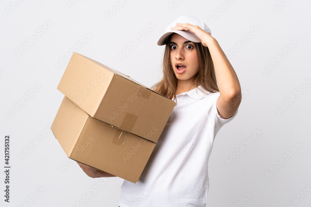 Young delivery woman over isolated white background doing surprise gesture while looking to the side Young delivery woman over isolated white background doing surprise gesture while looking to the side