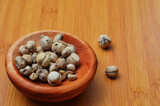 cardamom in a wooden bowl on a wooden tray. close up with selective focus