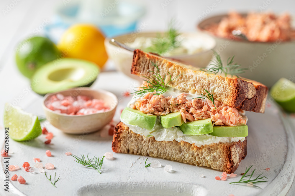 Homemade sandwich with avocado, salmon and dill for fresh lunch.