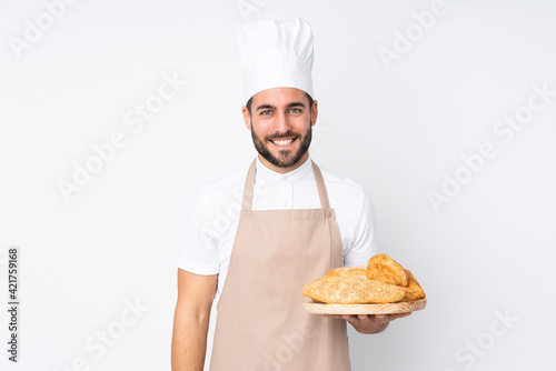 Fotografia Male baker holding a table with several breads isolated on white background laug