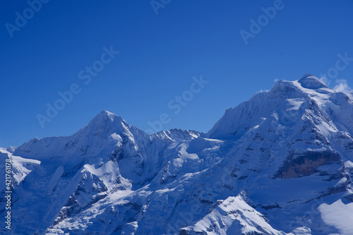 Panorama of Bernese Alps with Mountain Peaks Mönch (monk) and Jungfrau (virgin), seen from Mürren, Switzerland.