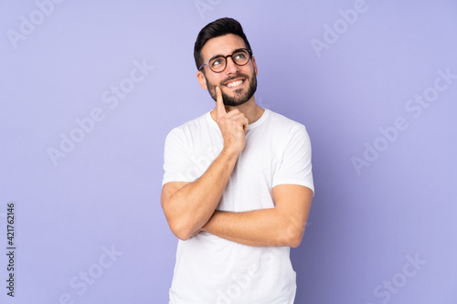 Caucasian handsome man over isolated background thinking an idea while looking up