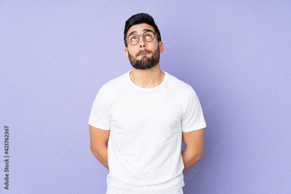 Caucasian handsome man over isolated background and looking up Caucasian handsome man over isolated background and looking up