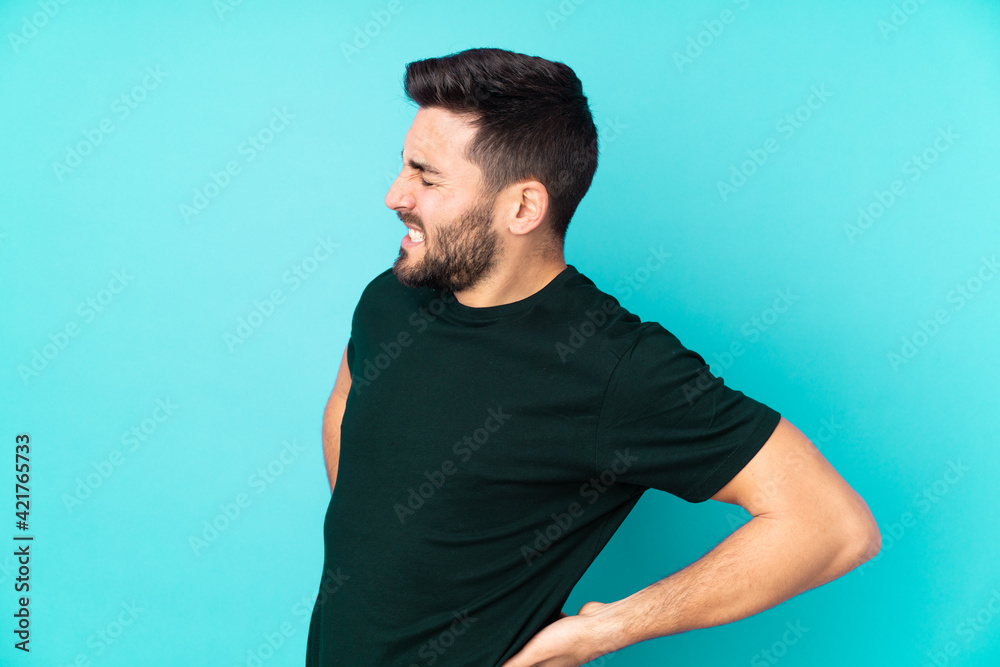 Caucasian handsome man isolated on blue background suffering from backache for having made an effort Caucasian handsome man isolated on blue background suffering from backache for having made an effort