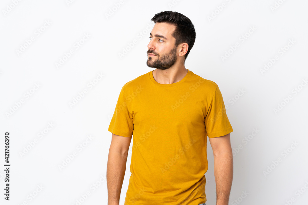 Young handsome man with beard isolated on white background looking to the side Young handsome man with beard isolated on white background looking to the side