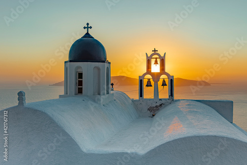 Romantischer Sonnenuntergng auf der Insel Santorin. Die Sonne versinkt in Imerovigli hinter der Kirche Theoskepasti in der Aegäis photo