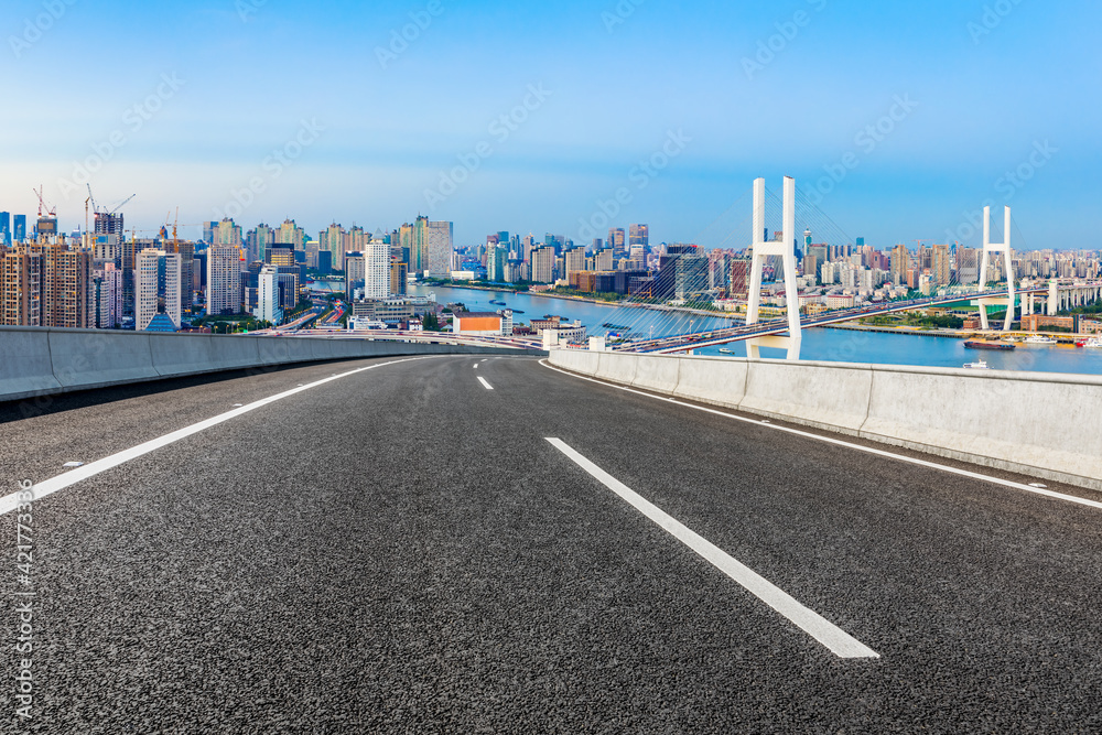 Asphalt highway and city skyline with bridge at dusk in Shanghai,China.