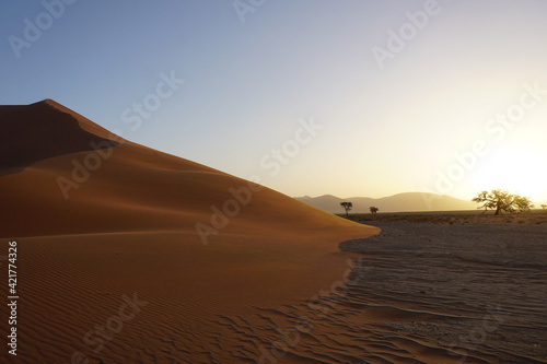 The red dunes of sossusvlei national park during sunset.