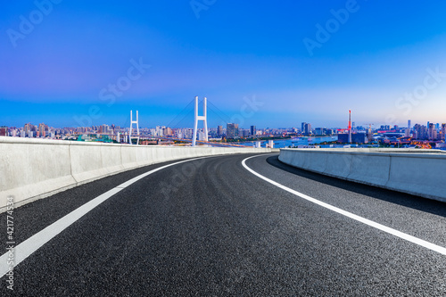 Asphalt highway and city skyline with bridge at night in Shanghai,China.