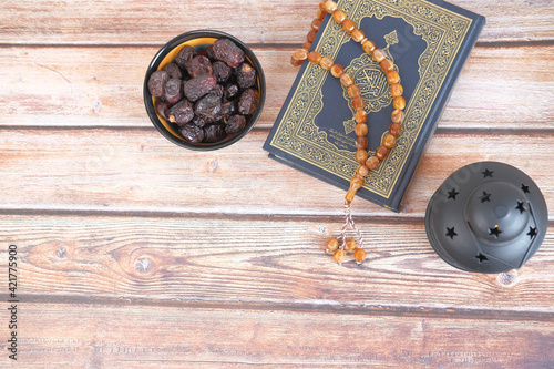 top view of date fruit , Holy book Quran and rosary on table,