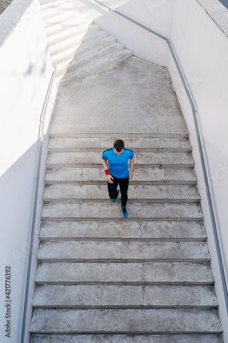 Young man running upstairs on city stairs. Fitness, sport, people, exercising and lifestyle concept