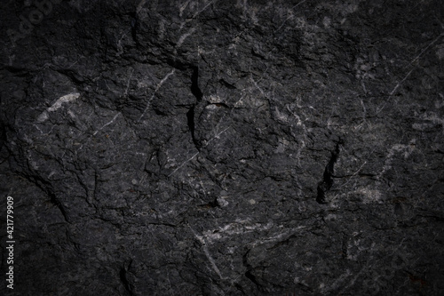 Rough cave stone wall surface with natural cracks used for background.