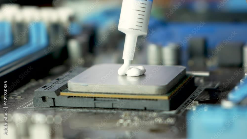 Replacing the micro processor on the computer. Close-up of thermal paste applied to processor while upgrading components. Computer components repair shop. Selective focus, shallow depth of field