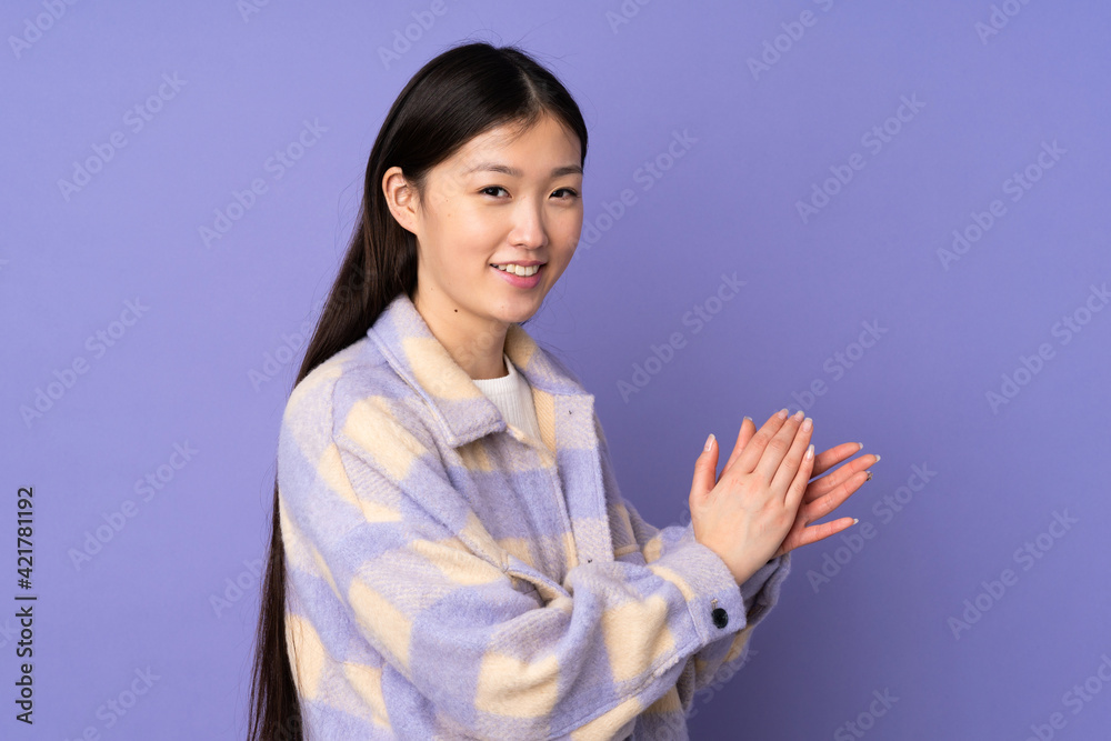 Young asian woman isolated on purple background applauding Young asian woman isolated on purple background applauding