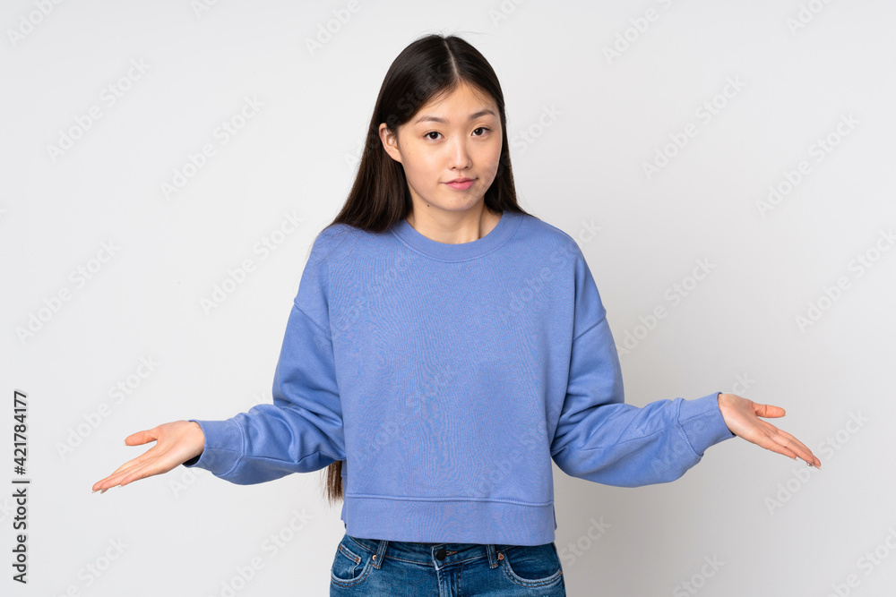 Young asian woman isolated on background having doubts Young asian woman isolated on background having doubts