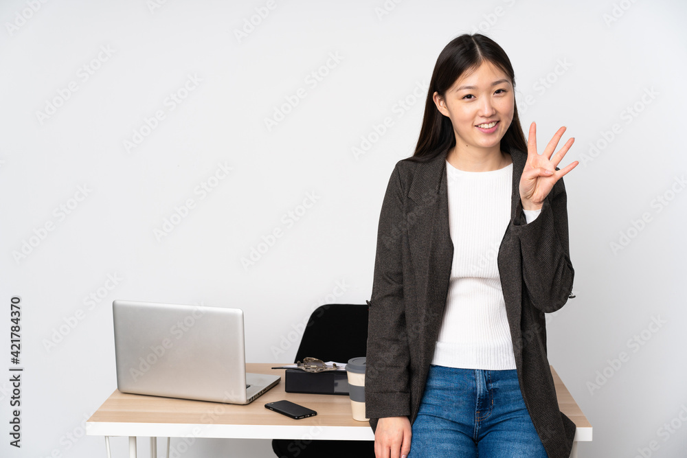 Business asian woman in her workplace isolated on white background happy and counting four with fingers Business asian woman in her workplace isolated on white background happy and counting four with fingers