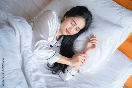 asian young woman enjoys fresh soft bedding linen and mattress in bedroom, Teenage girl resting, good night sleep concept.