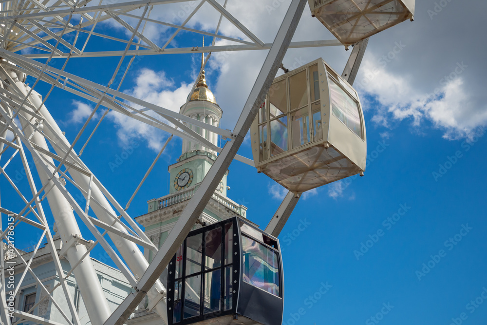 View of the old Bell Tower next to the ferris wheel on the Contract Square, Kyiv, Ukraine