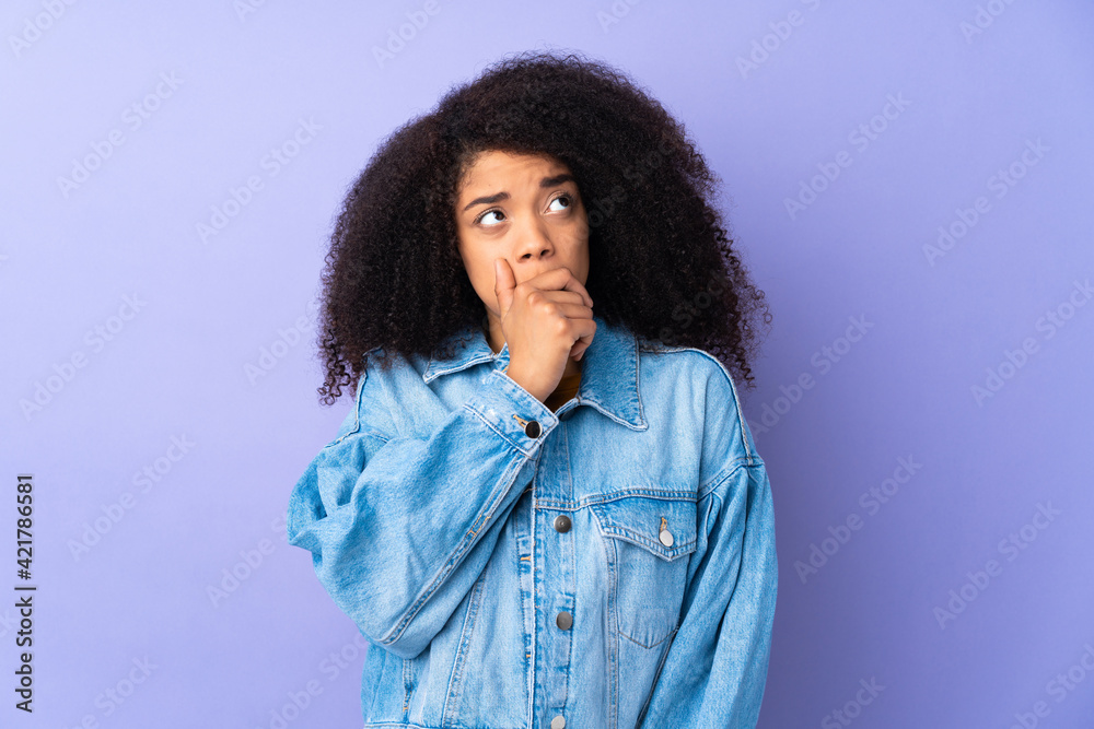 Young african american woman isolated on purple background having doubts and with confuse face expression Young african american woman isolated on purple background having doubts and with confuse face expression