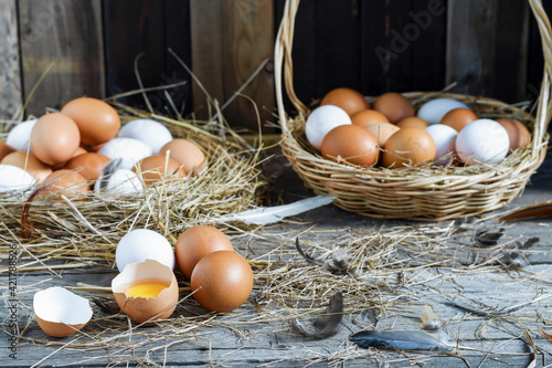Fresh eggs are placed on a wooden table and fresh eggs are placed in a basket in an organic farm.