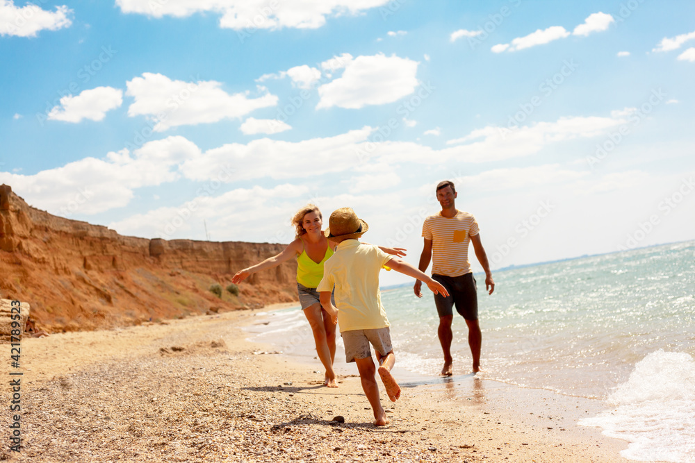 Active family, mother, father and son resting in the beach on vacation. people enjoy the sea, sand and healthy. Active family, mother, father and son resting in the beach on vacation. people enjoy the sea, sand and healthy.