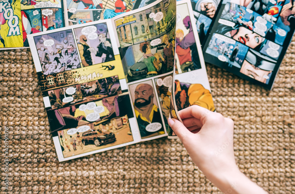 Obraz premium Woman reads manga comic book on the carpet at home. Rostov-on-Don, Russia. 18 March 2021