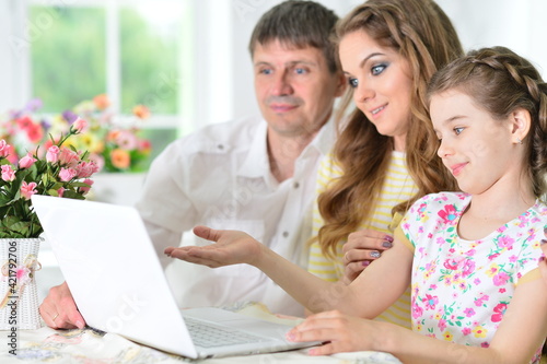 girl with mother and father drawing at home