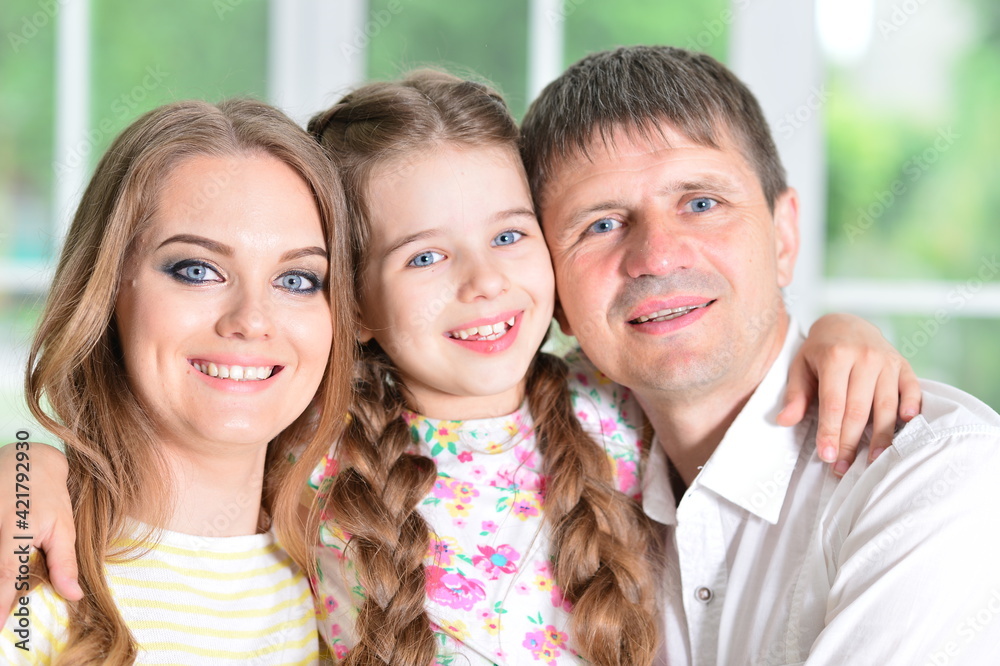 Happy parents and daughter posing in room Happy parents and daughter posing in room