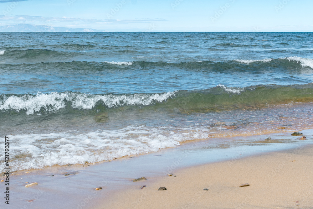 Seascape of the Lake Baikal. Waves with froth coming to the shore. Lifestyle. Seascape of the Lake Baikal. Waves with froth coming to the shore. Lifestyle.