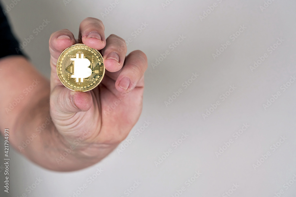 Hand holds coin with bitcoin symbol image Hand holds coin with bitcoin symbol image