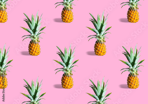 Seamless pattern of fresh ripe pineapples isolated on pink background. Exotic tropical fruit summer concept