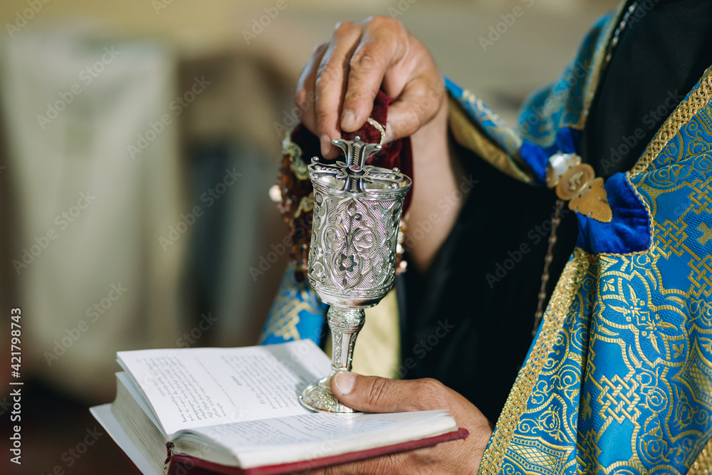 A closeup of hands of armenian priest doing wedding ceremony in armenian church