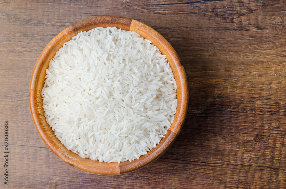 Organic Thai Jasmine rice grain in wooden bowl. Organic Thai Jasmine rice grain in wooden bowl.
