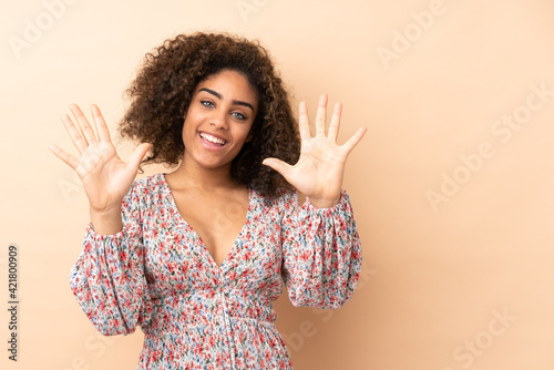Young African American woman isolated on beige background counting ten with fingers