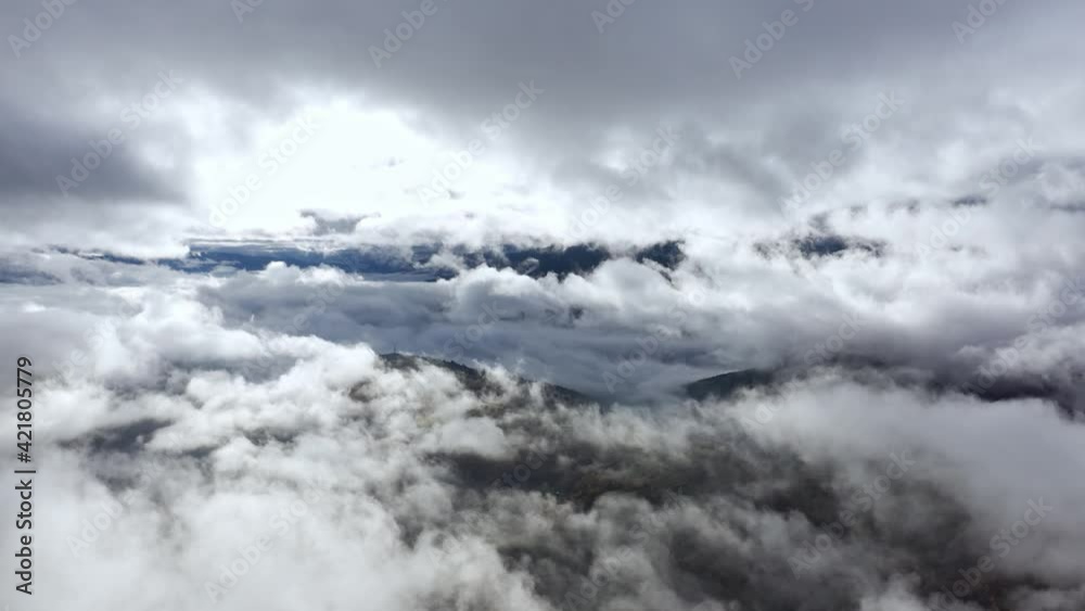 Flight through blue sky with clouds over mountain Flight through blue sky with clouds over mountain
