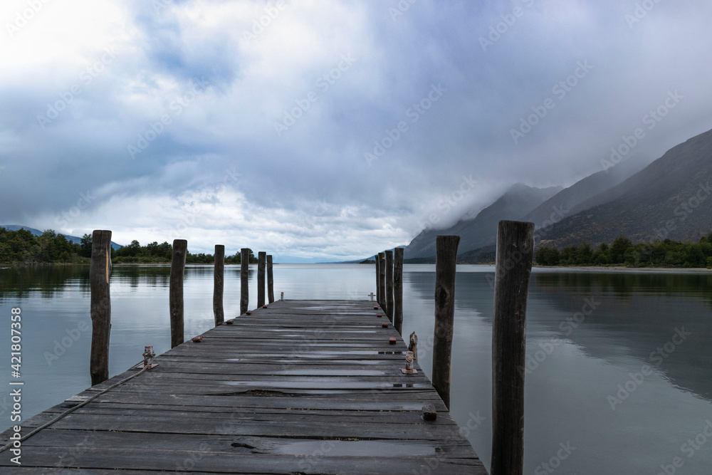 Naklejka premium pier in the quiet lake and cloudy sky