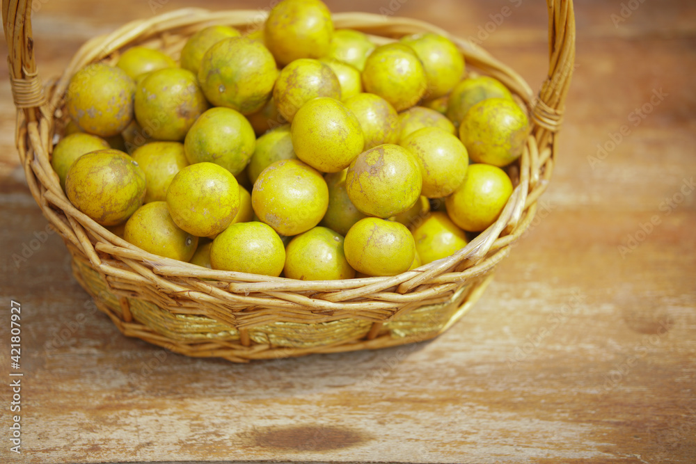 orange tangerine fruit in rattan wicker basket on wooden chair orange tangerine fruit in rattan wicker basket on wooden chair
